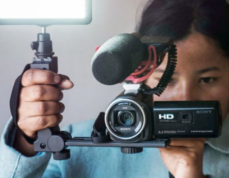 A young indigenous woman from North-East India holds a video camera